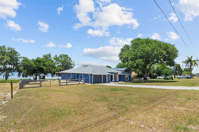 view of yard featuring an attached garage, driveway, and fence