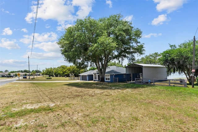 view of yard featuring fence and a carport