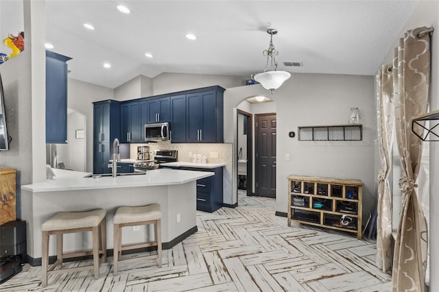 kitchen with appliances with stainless steel finishes, arched walkways, and blue cabinetry