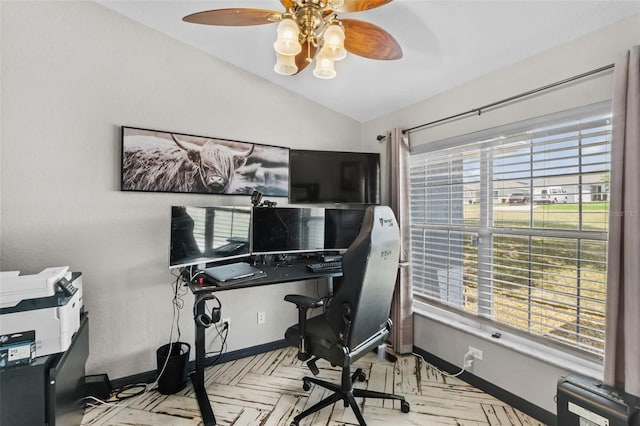 office area with vaulted ceiling, baseboards, and ceiling fan