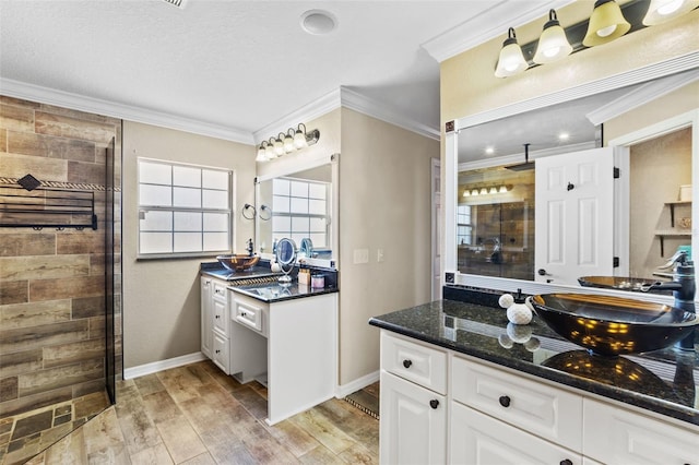 full bathroom featuring baseboards, wood finished floors, a tile shower, crown molding, and vanity