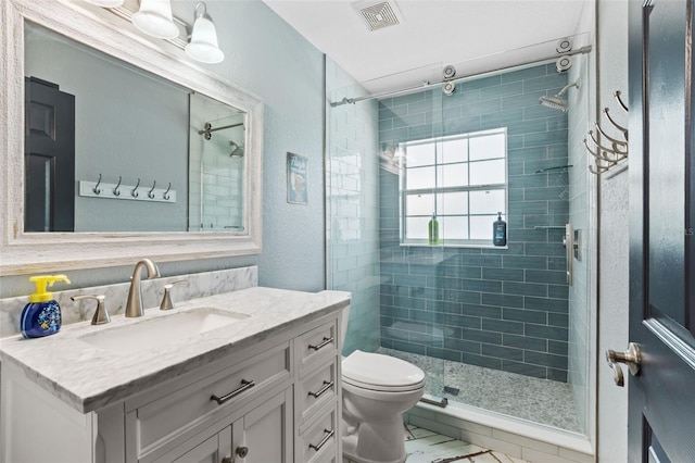 full bath with a stall shower, visible vents, vanity, and toilet