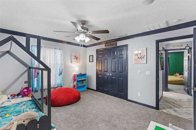 bedroom with a closet, visible vents, a textured ceiling, and carpet flooring