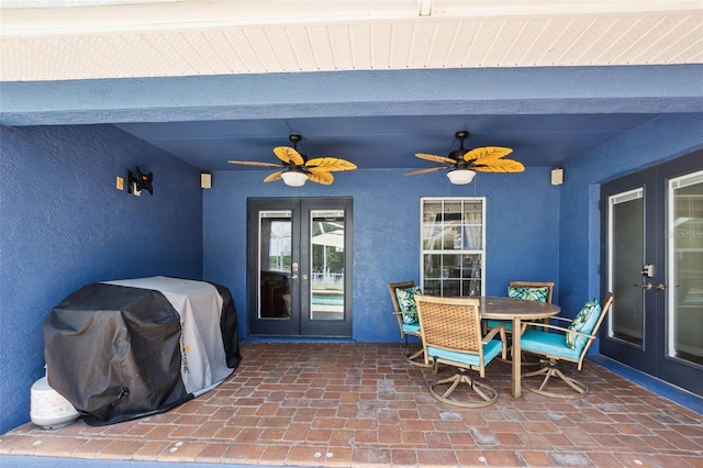 property entrance with french doors, stucco siding, a ceiling fan, outdoor dining space, and a patio area