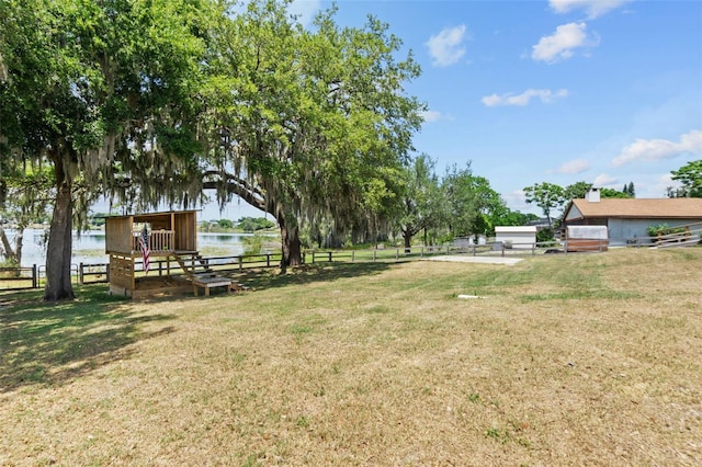 view of yard with a water view and fence