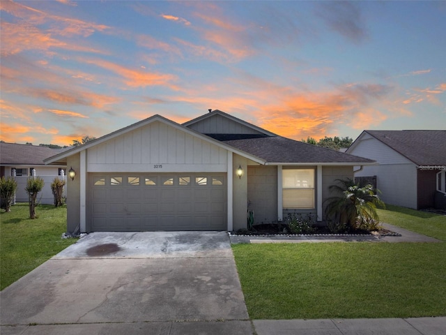 ranch-style house with a garage and a yard