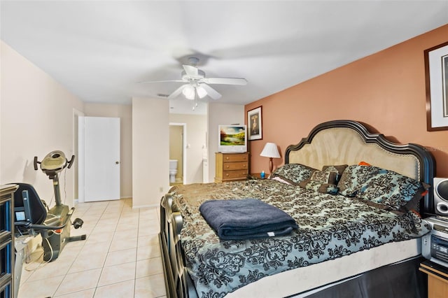 tiled bedroom featuring connected bathroom and ceiling fan