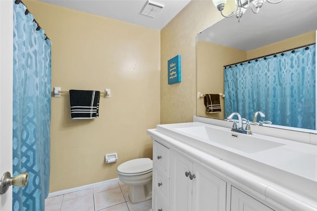 bathroom with tile flooring, vanity, and toilet