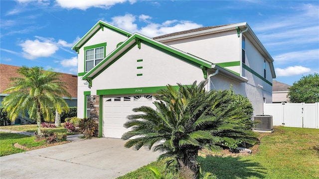 view of front of home with a garage, central air condition unit, and a front yard