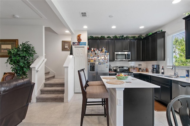 kitchen with tasteful backsplash, a kitchen island, light tile floors, and stainless steel appliances