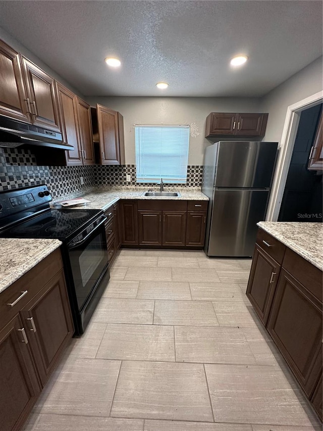 kitchen featuring electric range, sink, stainless steel fridge, and tasteful backsplash