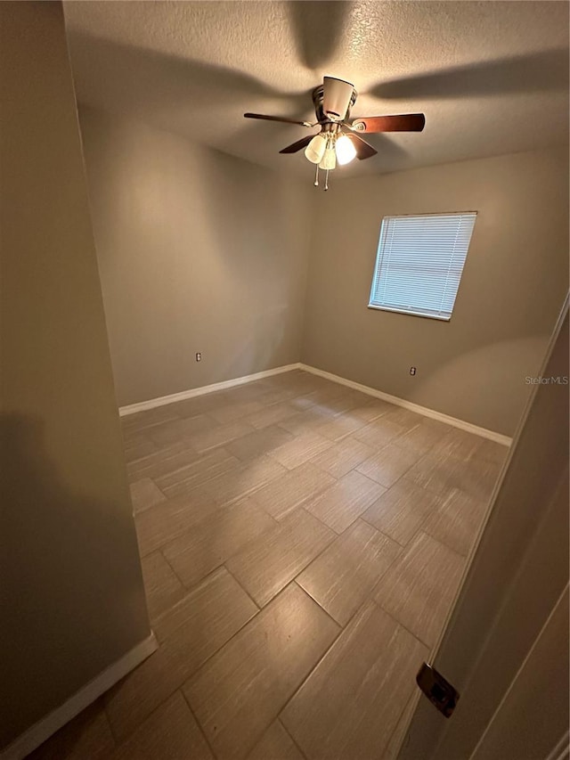 unfurnished room featuring ceiling fan and a textured ceiling