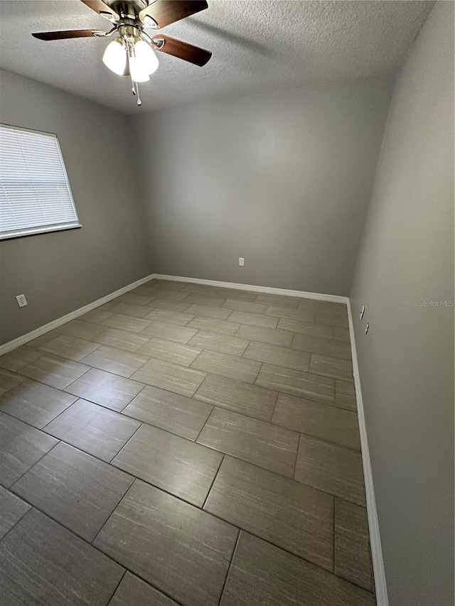 tiled spare room with ceiling fan and a textured ceiling