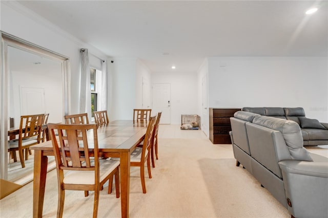 carpeted dining room featuring ornamental molding