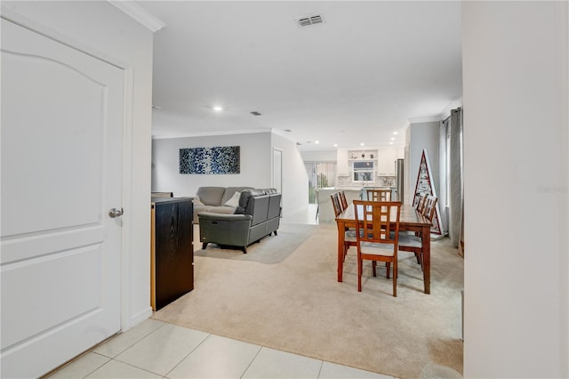 dining space featuring light carpet and crown molding