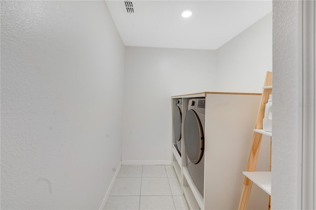 washroom with separate washer and dryer and light tile patterned floors