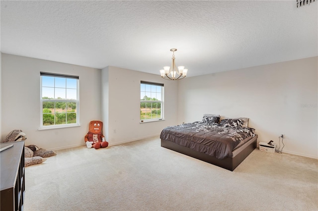 bedroom with carpet flooring, multiple windows, a chandelier, and a textured ceiling