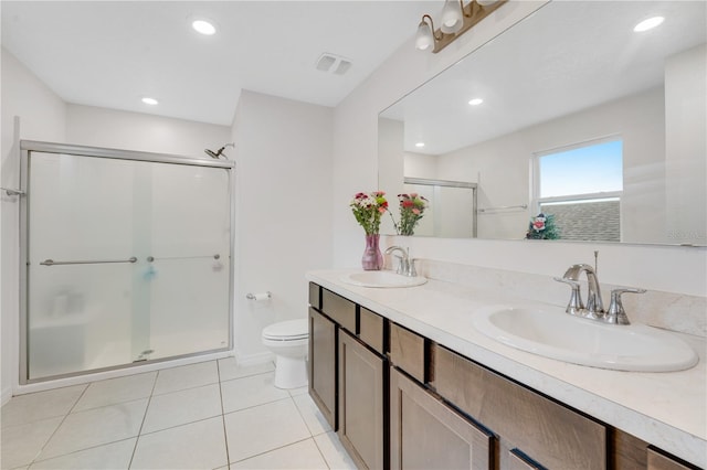 bathroom featuring tile patterned flooring, vanity, a shower with door, and toilet