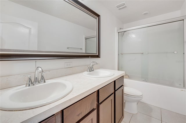 full bathroom featuring shower / bath combination with glass door, tile patterned floors, vanity, and toilet