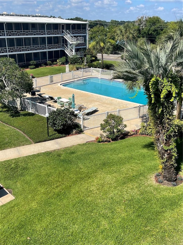 view of pool featuring a lawn and a patio area