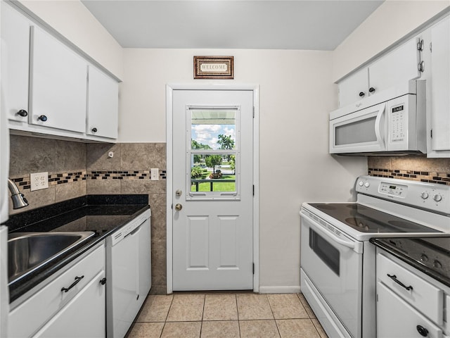 kitchen with white cabinets, white appliances, light tile floors, and tasteful backsplash