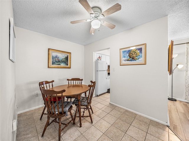 tiled dining room featuring ceiling fan and a textured ceiling