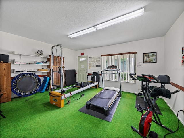 workout area with carpet flooring and a textured ceiling