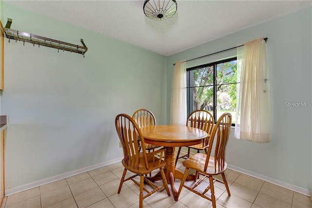 dining room with a textured ceiling and light tile flooring