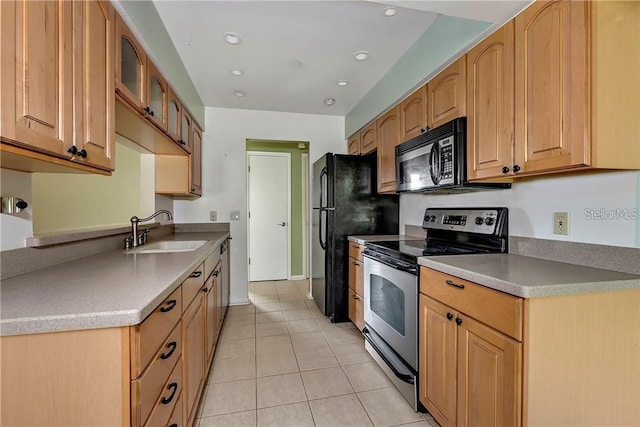 kitchen featuring stainless steel appliances, sink, and light tile floors