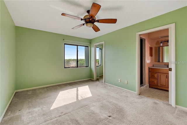 unfurnished bedroom with carpet, ceiling fan, and connected bathroom