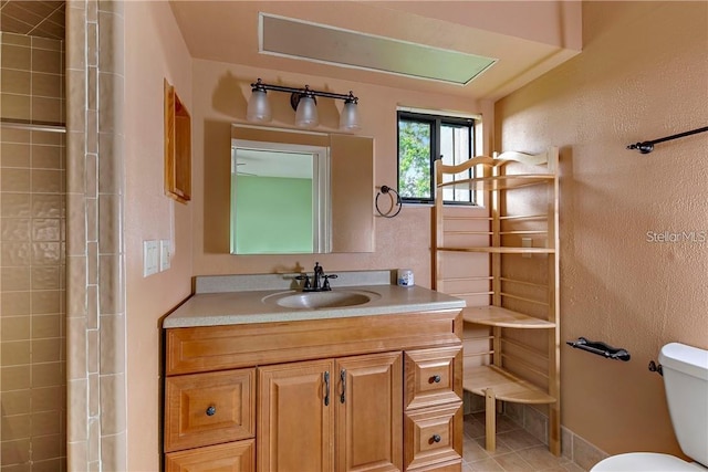 bathroom with tile floors, a shower with shower door, toilet, and large vanity