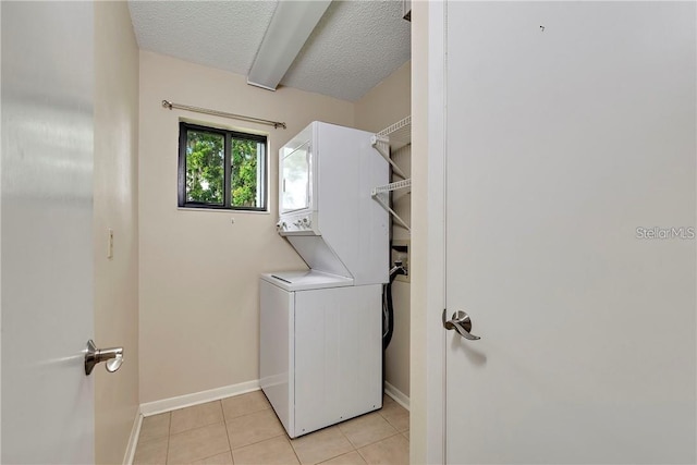 clothes washing area featuring hookup for a washing machine, stacked washer / drying machine, a textured ceiling, and light tile floors