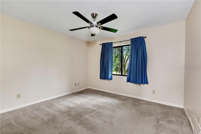 carpeted spare room featuring ceiling fan and a textured ceiling