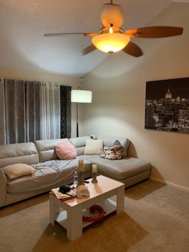 living room featuring a textured ceiling, ceiling fan, carpet floors, and lofted ceiling