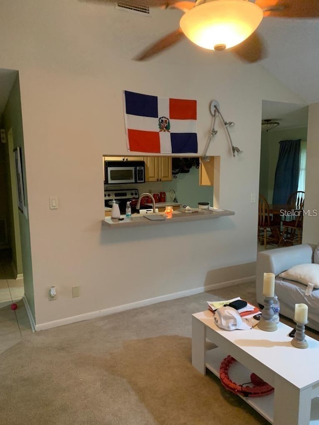 carpeted living room with ceiling fan and vaulted ceiling