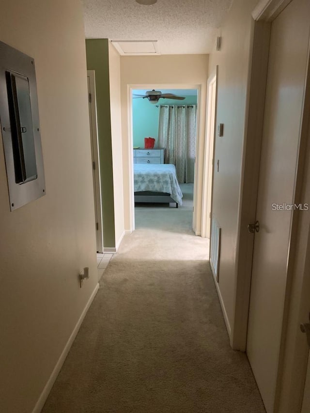 corridor featuring a textured ceiling and carpet floors