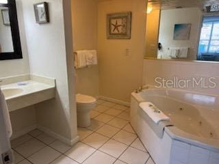 bathroom with tile floors, tiled bath, and toilet