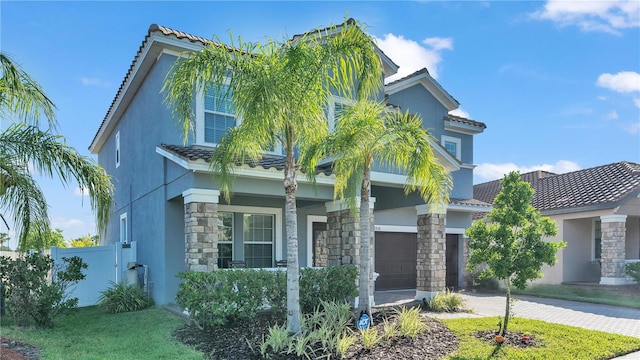 view of front facade with decorative driveway, fence, a garage, and stucco siding