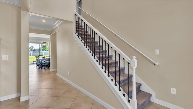 staircase featuring tile patterned flooring and crown molding