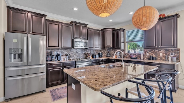 kitchen with light tile patterned flooring, appliances with stainless steel finishes, a kitchen island with sink, and decorative backsplash