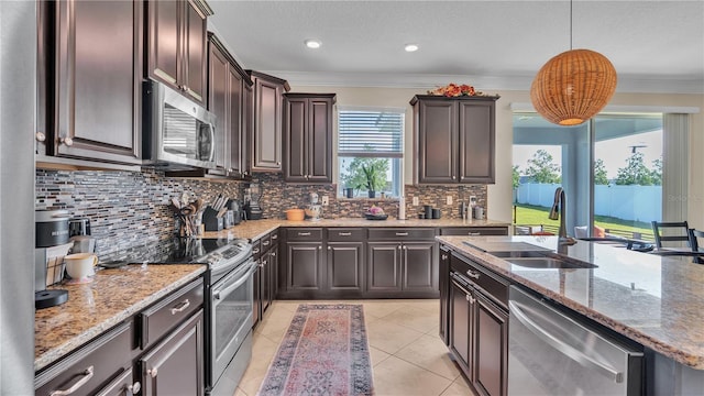 kitchen featuring decorative backsplash, light tile patterned floors, sink, decorative light fixtures, and stainless steel appliances