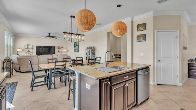 kitchen with ceiling fan, stainless steel dishwasher, a center island with sink, and decorative light fixtures