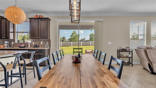 tiled dining area featuring a wealth of natural light and ornamental molding