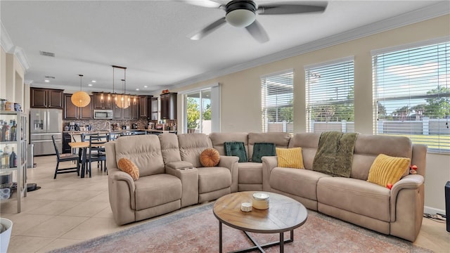 tiled living room with ceiling fan and crown molding