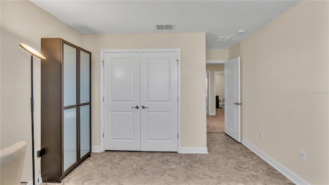 unfurnished bedroom featuring a closet and light tile patterned floors