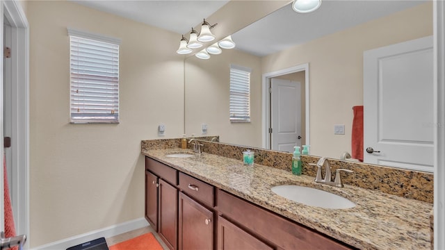 bathroom with tile patterned flooring, double sink vanity, and a healthy amount of sunlight