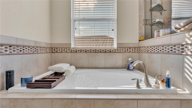 bathroom featuring a healthy amount of sunlight and tiled bath