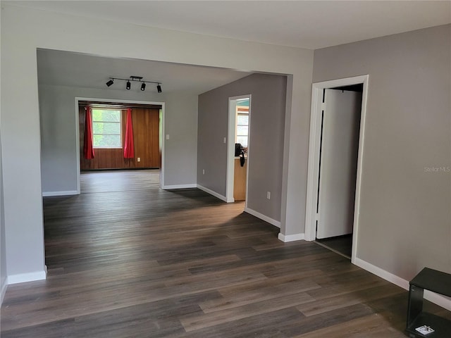 spare room with dark hardwood / wood-style flooring and rail lighting