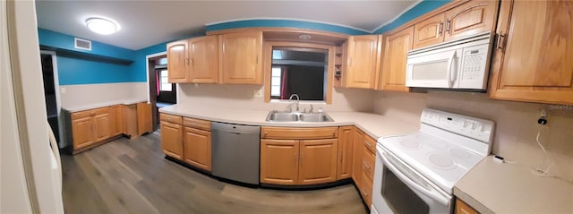 kitchen featuring white appliances, sink, and dark hardwood / wood-style floors