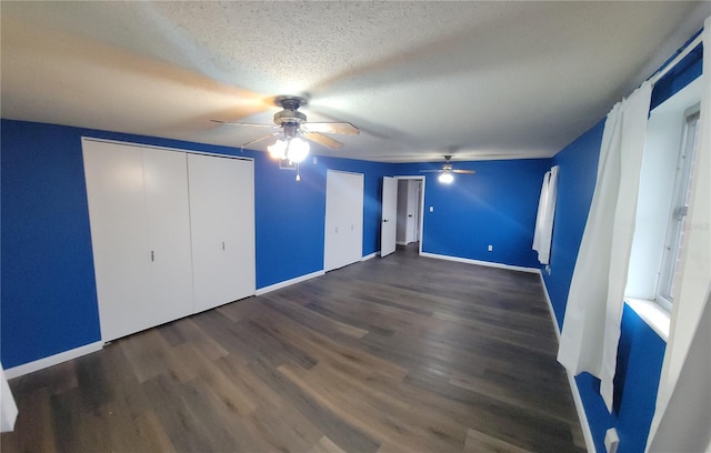 unfurnished bedroom with a textured ceiling, a closet, ceiling fan, and dark hardwood / wood-style flooring